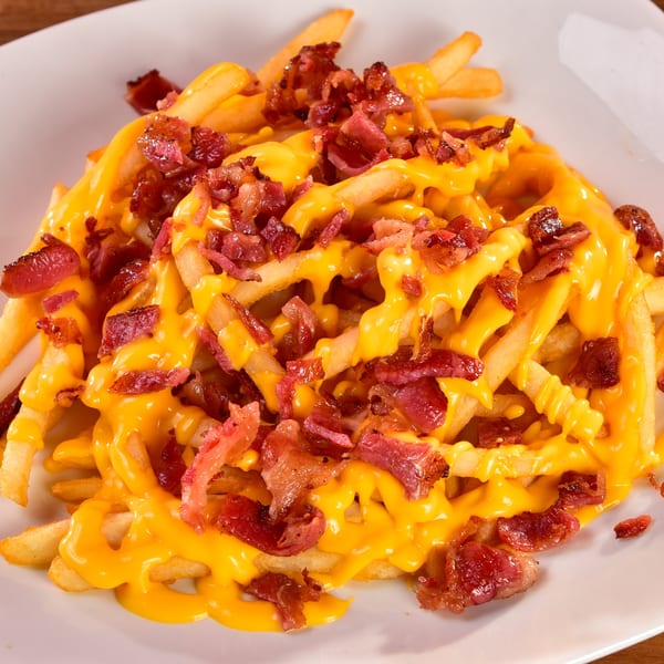 Fred's Burger's golden french fries generously topped with melted cheese and crispy bacon bits.