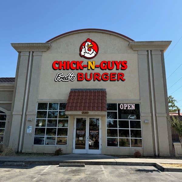Fred's Burger restaurant exterior with "Chick-N-Guys Fred's Burger" sign and an "Open" sign in the window.