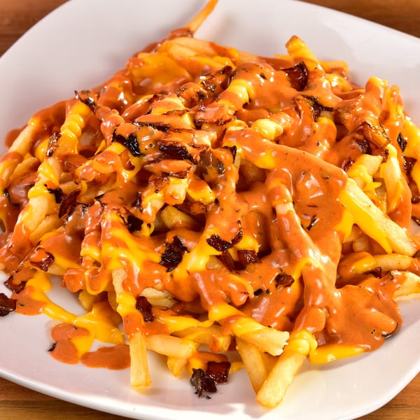 Fred's Burger's loaded fries with melted cheese, orange sauce, and crispy bacon bits.