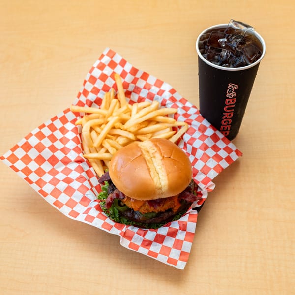 Fred's Burger meal with a burger, fries in a red checkered basket, and a soda.